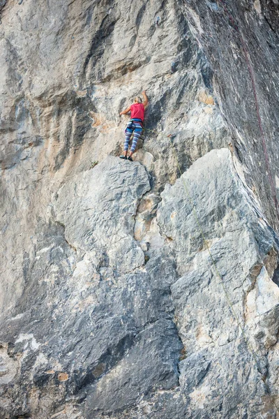 Uma mulher alpinista numa rocha . — Fotografia de Stock