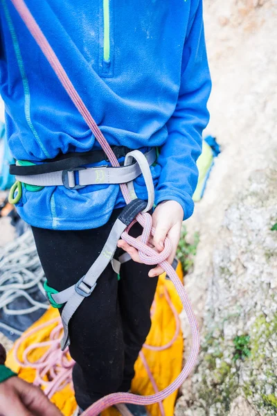 Ein Bergsteiger knüpft einen Knoten für die Versicherung. — Stockfoto