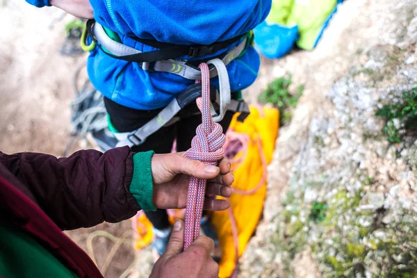 Een bergbeklimmer Leg een knoopje voor verzekering. — Stockfoto