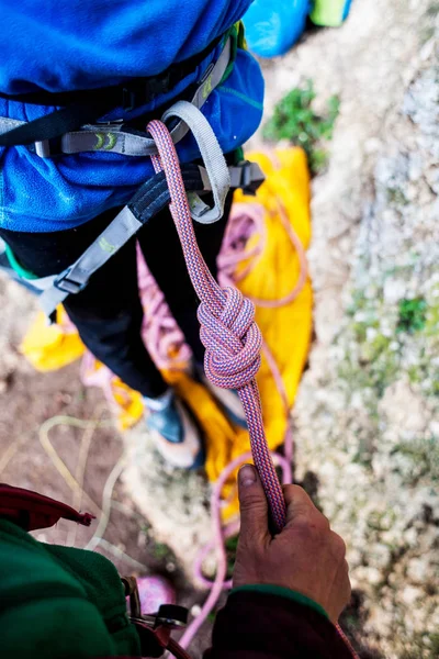 Ein Bergsteiger knüpft einen Knoten für die Versicherung. — Stockfoto