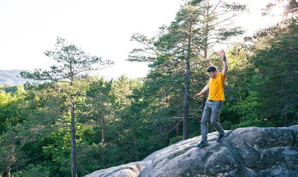 A man balances on a stone.