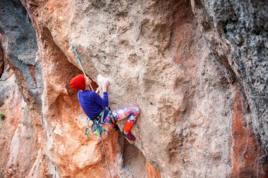 Bir dağcı bir kayanın üzerinde.
