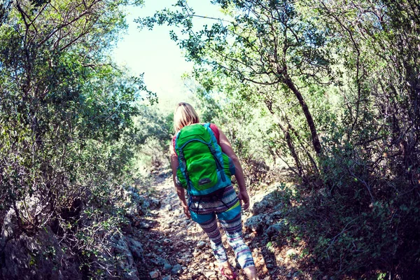 Mujer con una mochila en las montañas. — Foto de Stock