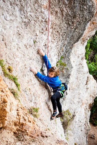 Le garçon grimpe le rocher . — Photo