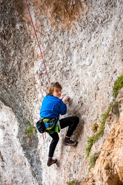 Le garçon grimpe le rocher . — Photo