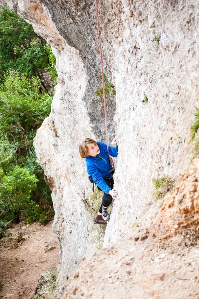 Le garçon grimpe le rocher . — Photo