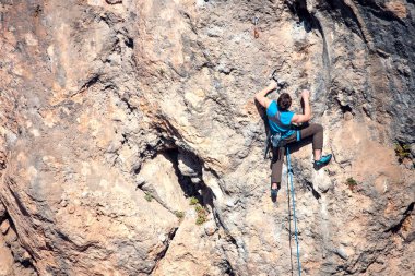 Bir adam kaya tırmanıyor.