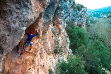 Bir dağcı bir kayanın üzerinde.