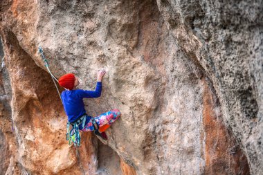 Bir dağcı bir kayanın üzerinde.