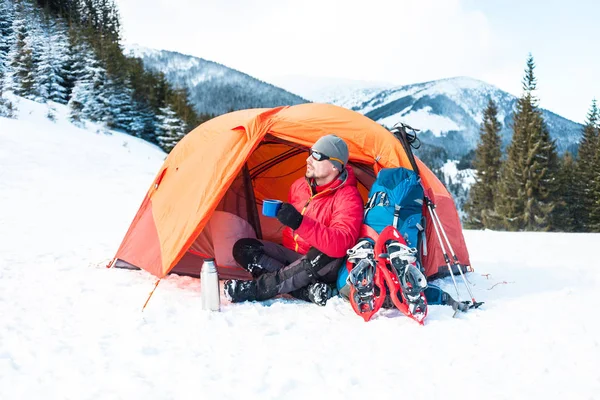 Ein Mann in der Nähe eines Zeltes im Winter. — Stockfoto