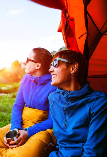 two girls having fun near the tent camping