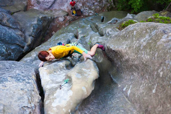 Flicka klättrare klättrar rock. — Stockfoto