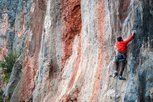 Un hombre sube a la roca . — Foto de Stock