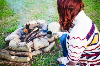 Bir kız tarafından yangın kahve içiyor.