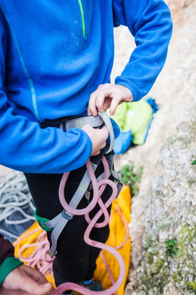 Um alpinista dá um nó por seguro. . — Fotografia de Stock