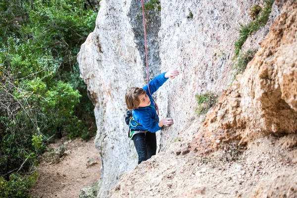 El chico sube a la roca . — Foto de Stock