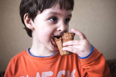 Oğlan dondurma yiyor.