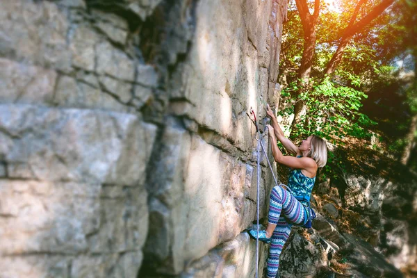 Flicka klättrare på en sten. — Stockfoto