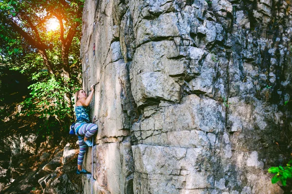 Chica escalador en una roca . — Foto de Stock