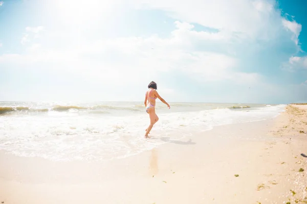Ένα κορίτσι είναι το περπάτημα κατά μήκος της παραλίας. — Φωτογραφία Αρχείου