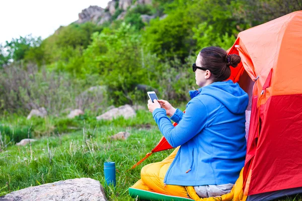 La ragazza è seduta vicino alla tenda . — Foto Stock