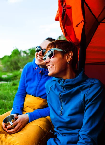 two girls having fun near the tent camping