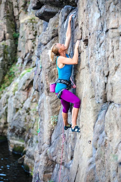 En kvinna klättrar rock. — Stockfoto