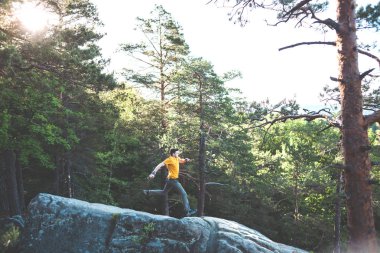 Bir adam bir taşa dengeler.