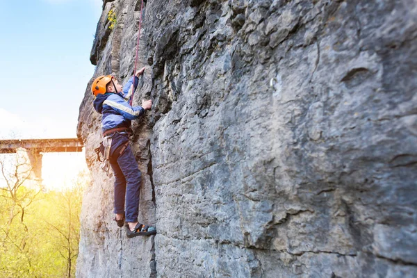 Kid escalador de rocha sobe o penhasco . — Fotografia de Stock