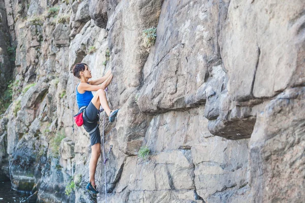 Una mujer sube a la roca . —  Fotos de Stock