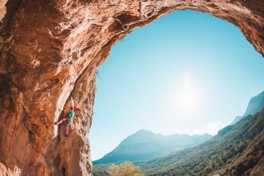 Bir dağcı kaya tırmanıyor.