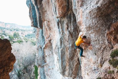 Bir adam kaya tırmanıyor. Doğada tırmanma. Fitness açık havada. Aktif yaşam tarzı. Ekstrem Sporlar. Doğal bir rahatlama atlet trenlerde. Türkiye'de dağcılık.