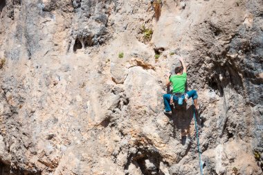 Bir adam kaya tırmanıyor. Doğada tırmanma. Fitness açık havada. Aktif yaşam tarzı. Ekstrem Sporlar. Doğal bir rahatlama atlet trenlerde.