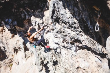 Bir kadın rock tırmanıyor. Doğada tırmanma. Fitness açık havada. Aktif yaşam tarzı. Ekstrem Sporlar. Doğal bir rahatlama atlet trenlerde.