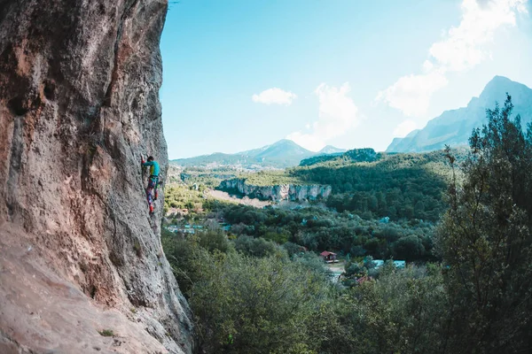 A woman climbs the rock. Climbing in nature. Fitness outdoors. Active lifestyle. Extreme sports. The athlete trains on a natural relief. Training in a picturesque place. Rock climbing in Turkey.