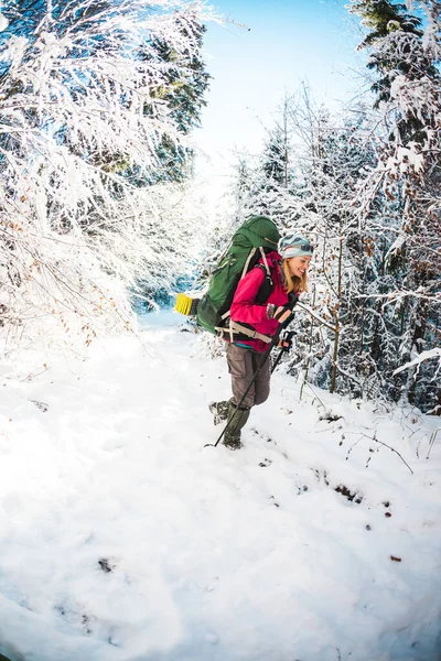 Vrouw met rugzak en sneeuwschoenen in de winter bergen. — Stockfoto