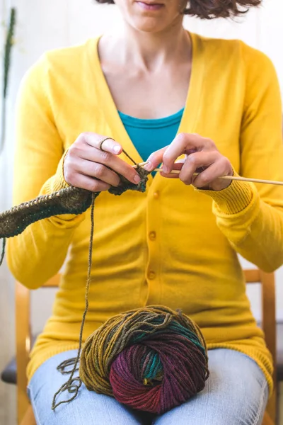 Jovem mulher está tricotando . — Fotografia de Stock