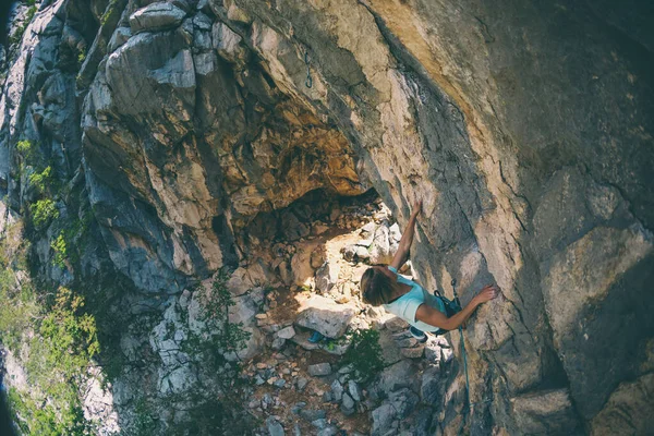 Uma menina sobe uma rocha . — Fotografia de Stock