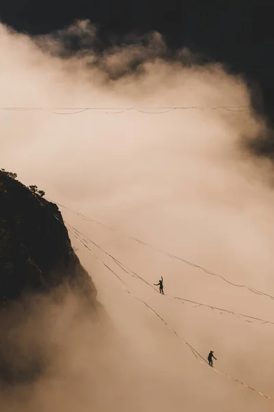 İki dağcı bulutun üstünde bir çizgi üzerinde.. — Stok fotoğraf
