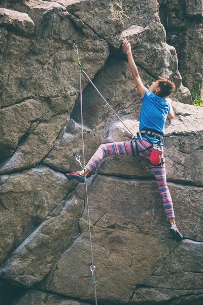 La chica sube a la roca de granito . —  Fotos de Stock