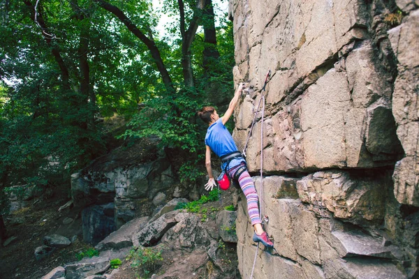 La chica sube a la roca de granito . —  Fotos de Stock