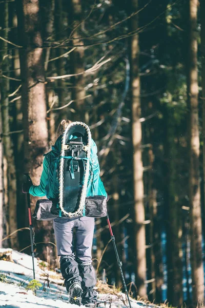 冬の山でバックパックとスノーシューを持つ女性. — ストック写真