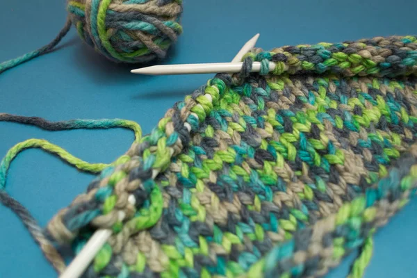 Knitting needles and multi-colored threads.