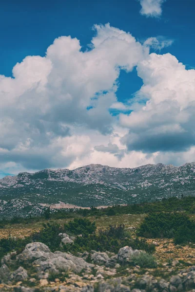 Berge vor einem schönen blauen Himmel mit flauschigen Wolken. — Stockfoto