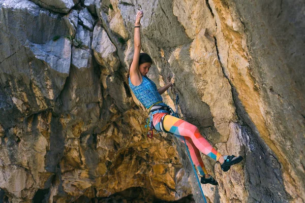 Een meisje klimt op een rots. — Stockfoto