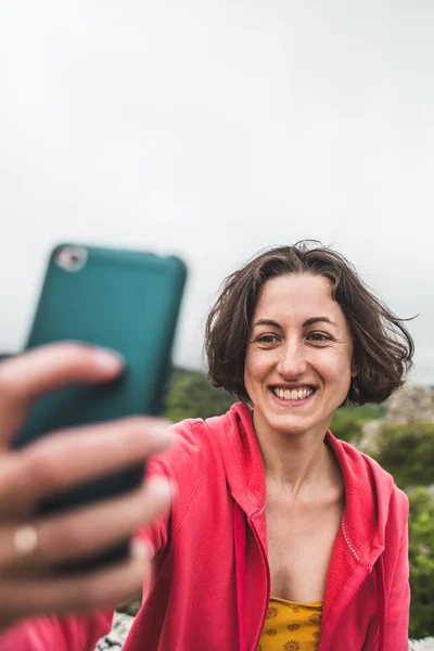 Kobieta bierze selfie na szczycie góry. — Zdjęcie stockowe