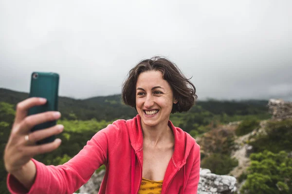 Kobieta bierze selfie na szczycie góry. — Zdjęcie stockowe