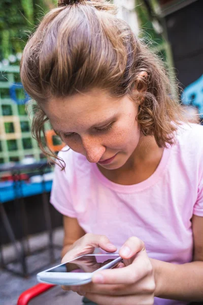 Uśmiechnięta dziewczyna z telefonem w rękach. — Zdjęcie stockowe