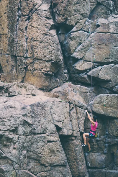 La chica sube a la roca de granito . — Foto de Stock