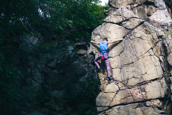 Das Mädchen erklettert den Granitfelsen. — Stockfoto